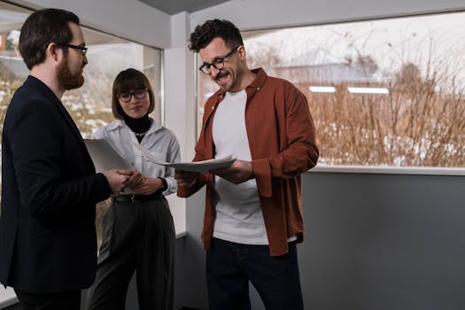 A group of professionals discussing documents in a bright office space, focusing on teamwork and collaboration.