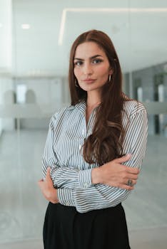 Professional woman with brown hair in a modern office, exuding confidence and poise.