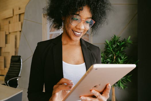 Smiling woman using a tablet in a modern office setting, showcasing technology and business.