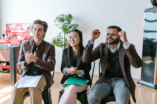 A group of diverse entrepreneurs in a workspace celebrating success and motivation.