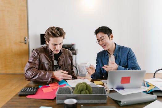 Two business professionals discuss ideas and strategies in an office setting, fostering innovation and teamwork.